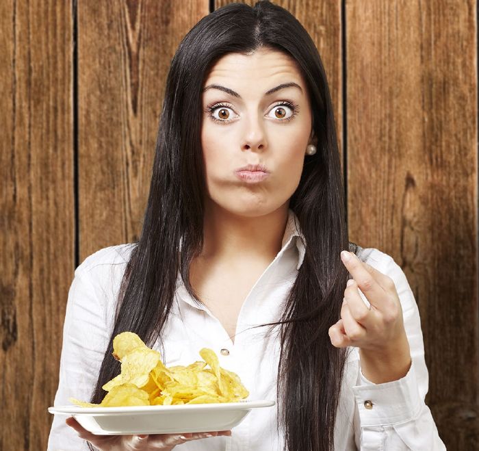 resized_surprised woman eating plate of potato chips