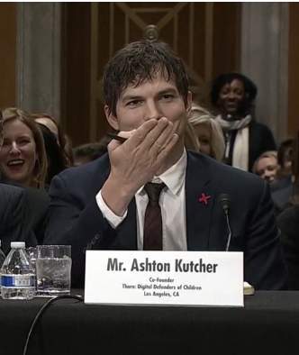 أشتون كوتشر يلقي قبلة في الهواء في اتجاه ماكين