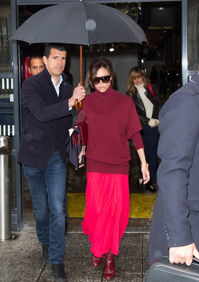 سارت فيكتوريا في الشارع تحت مظلة سوداء