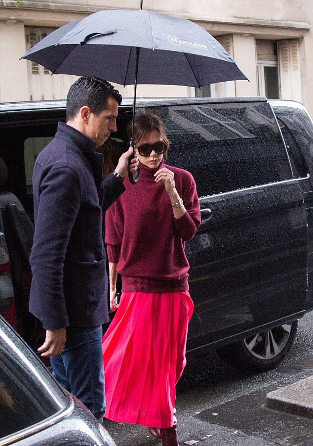 فيكتوريا بيكهام مع حارسها الخاص تحت مظلة سوداء